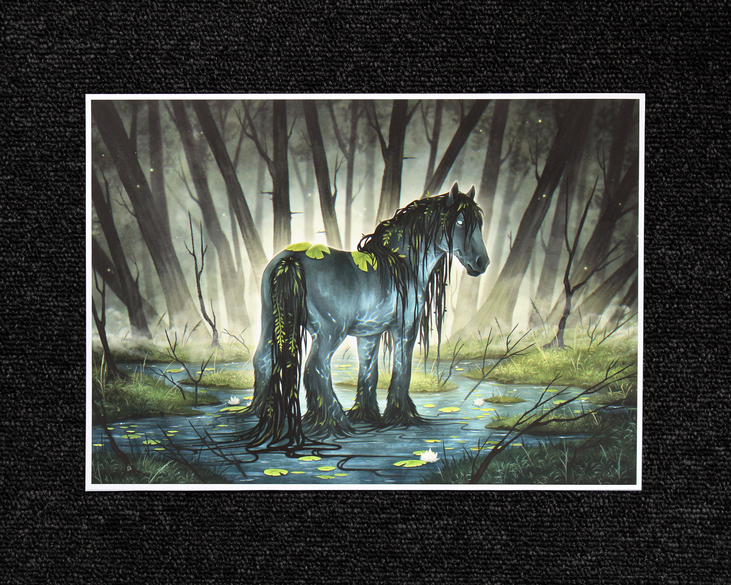 A4 print of the mythical Kelpie. A dark greyish blue horse stood on the waters surface, surrounded by a dark forest background