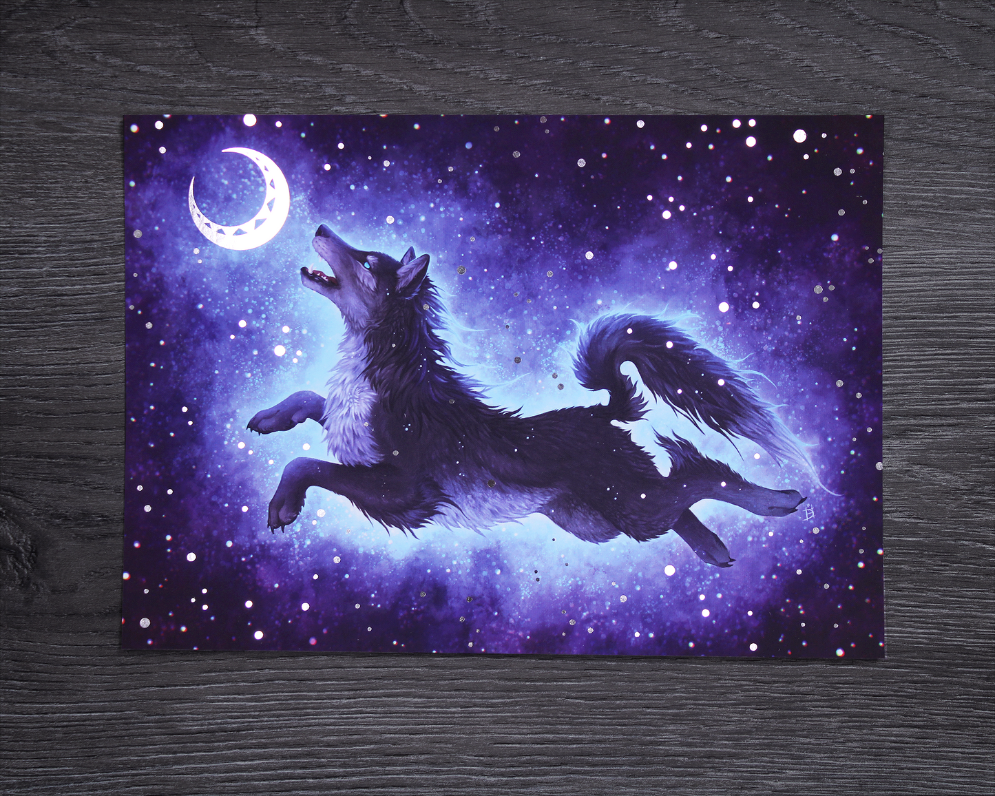 A5 foil print showing the Norse Wolf Hati, chasing the moon on a blue starry background. The stars and moon are in silver foil
